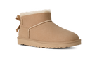 A single tan suede ankle boot with a white shearling lining, a decorative side bow, and a thick lug sole, shown on a plain white background.