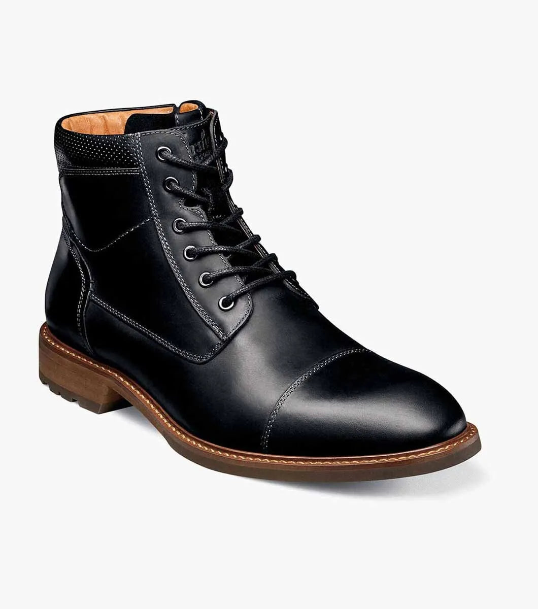 Black leather boot with brown sole on a white background