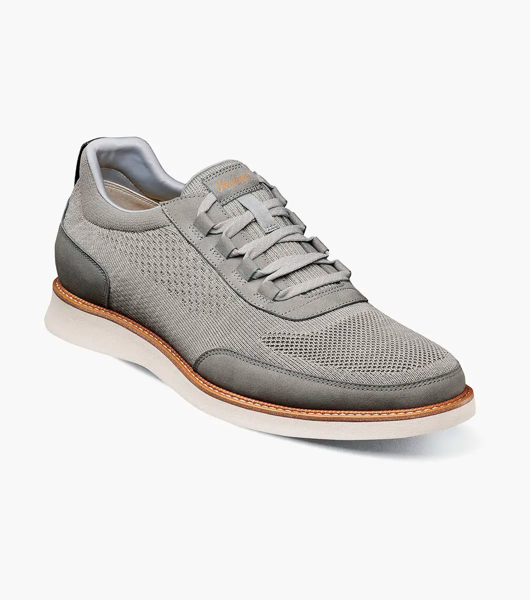 Gray sneaker with a brown sole on a white background