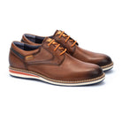 Pair of brown leather shoes with orange laces on a white background
