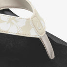 Close-up of a visor with floral pattern and brand logo on a black background