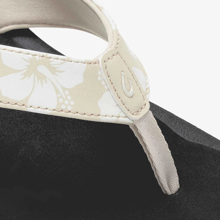 Close-up of a visor with floral pattern and brand logo on a black background