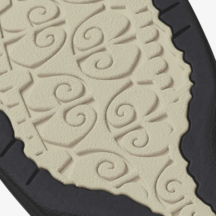 Close-up of a textured shoe sole with intricate patterns on a beige background