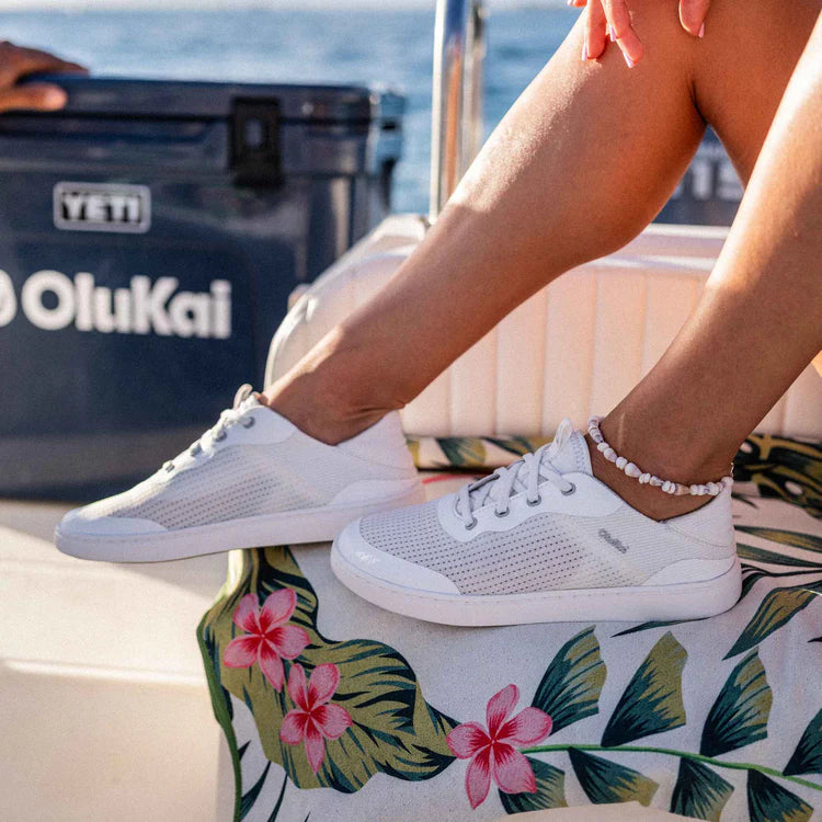 Person wearing white sneakers on a boat with a Viti Olukai cooler in the background