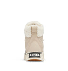 A beige Sorel mid-height winter boot with a cream sherpa lining and a black Sorel logo patch on the heel, shown from the back on a white background.
