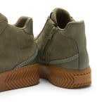 Close-up rear view of olive green suede and leather mid-top boots with side zippers and brown lug soles, shown on a white background. The SOREL brand name is visible on the heel and side.