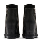 A pair of black leather ankle boots shown from the back, featuring side zippers, a stacked lug sole, and a debossed SOREN logo on the heel.
