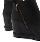 Black wedge ankle boots with a side zipper and a visible Sorel brand tab on the heel, shown on a white background.