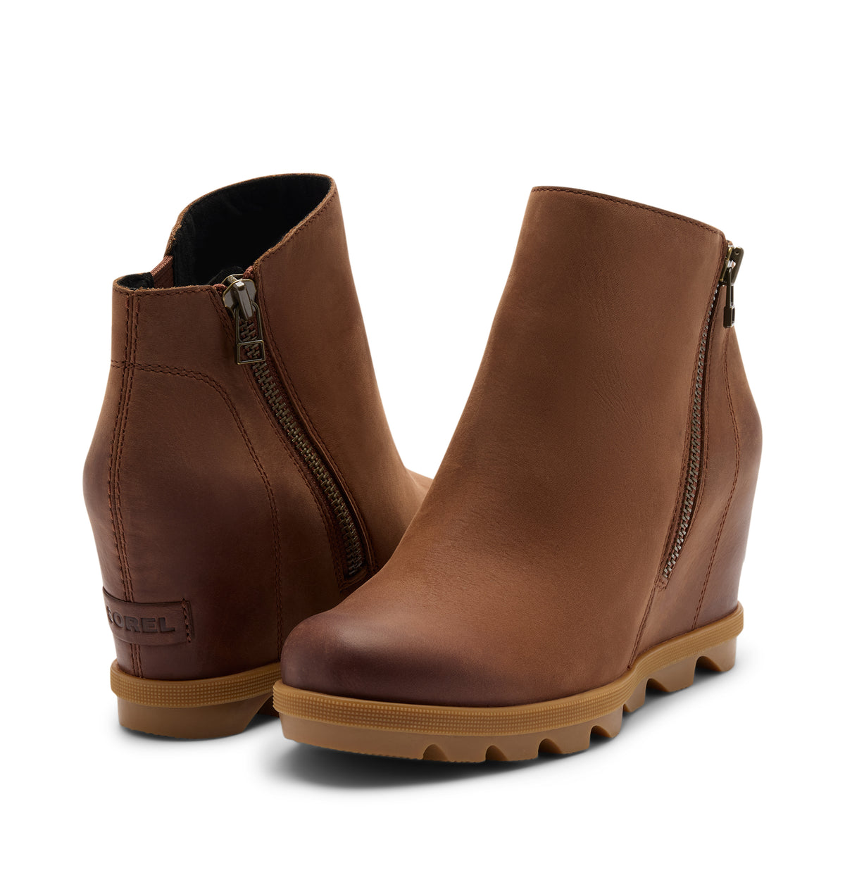 A pair of brown leather wedge ankle boots with side zippers and chunky lug soles, shown on a clean white background.