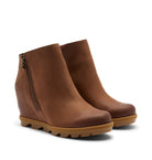 A pair of women's wedge ankle boots in smooth brown leather with a side zipper and chunky lug soles, shown on a light beige background.