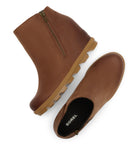 A pair of brown leather ankle boots with side zippers, shown from a top-down angle on a white background. One boot is upright, and the other is tilted on its side to show the black insole with the white 'SOREL' brand logo.