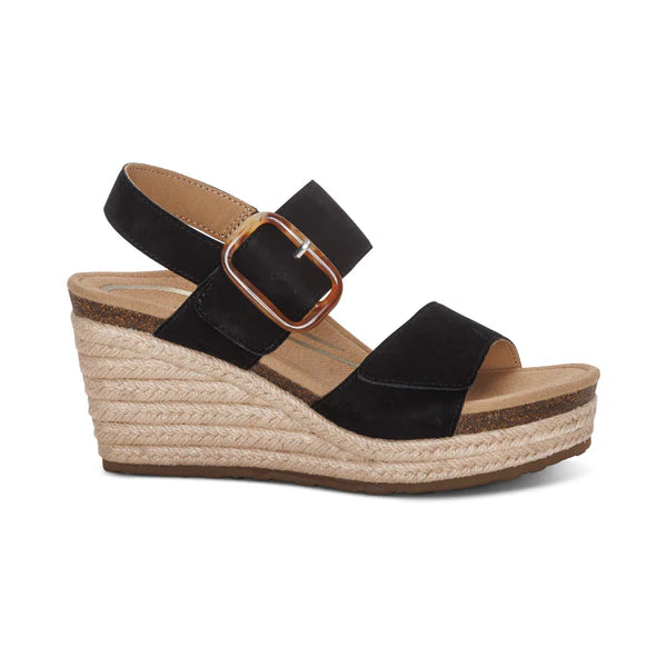 Black wedge sandal with a brown strap and espadrille sole on a white background