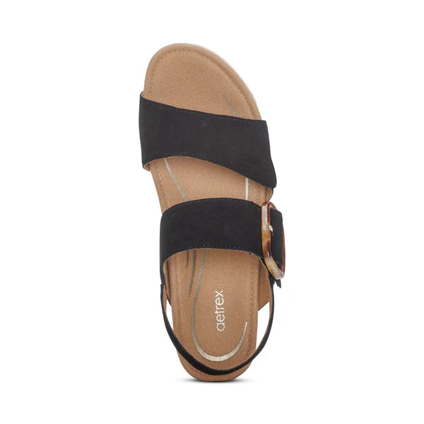 Black sandal with a brown sole on a white background