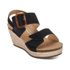 Black wedge sandal with a brown strap and cork sole on a white background