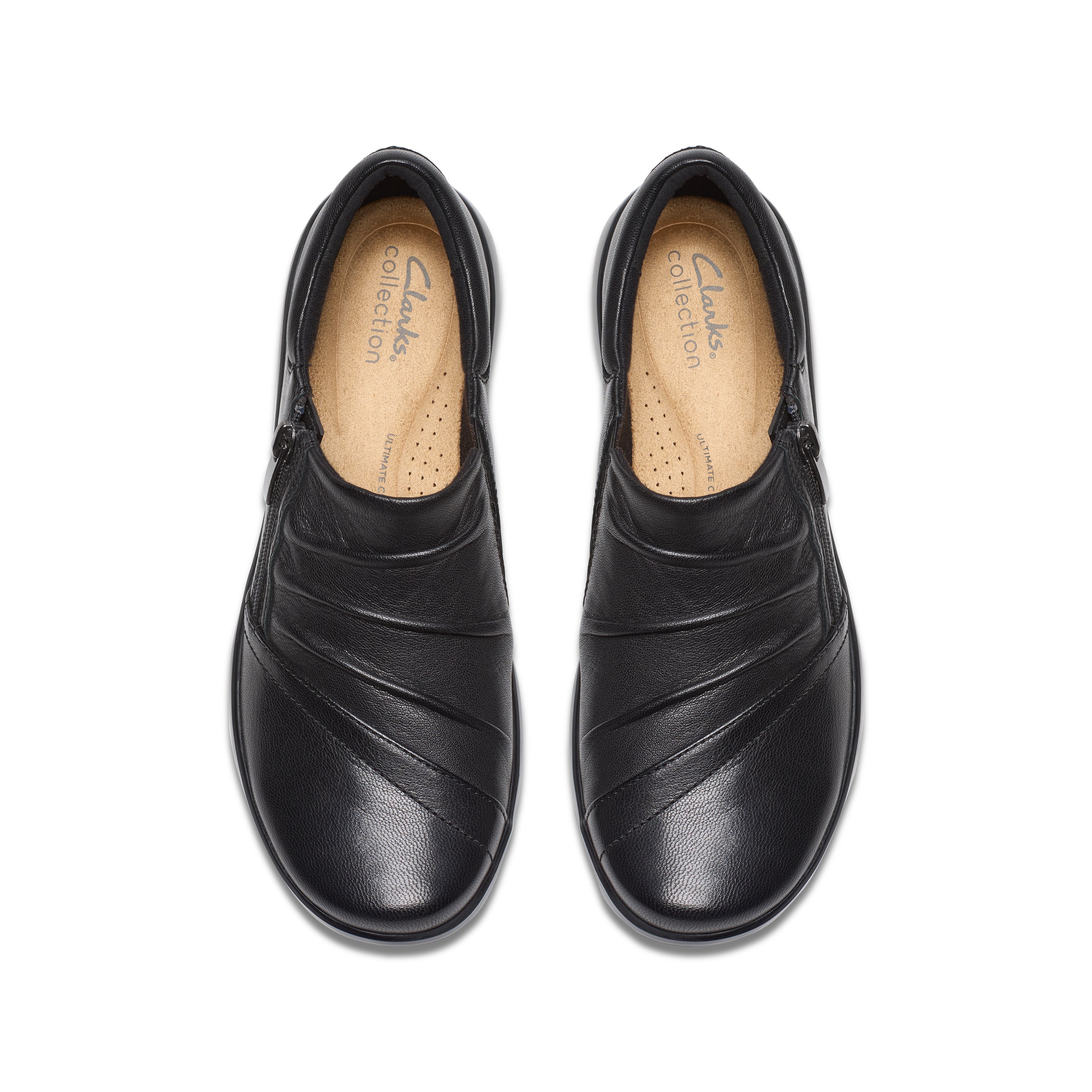 A pair of black leather slip-on shoes with diagonal stitched detailing on the toe, shown from a top-down view on a white background. The insoles show the Clarks Collection logo.