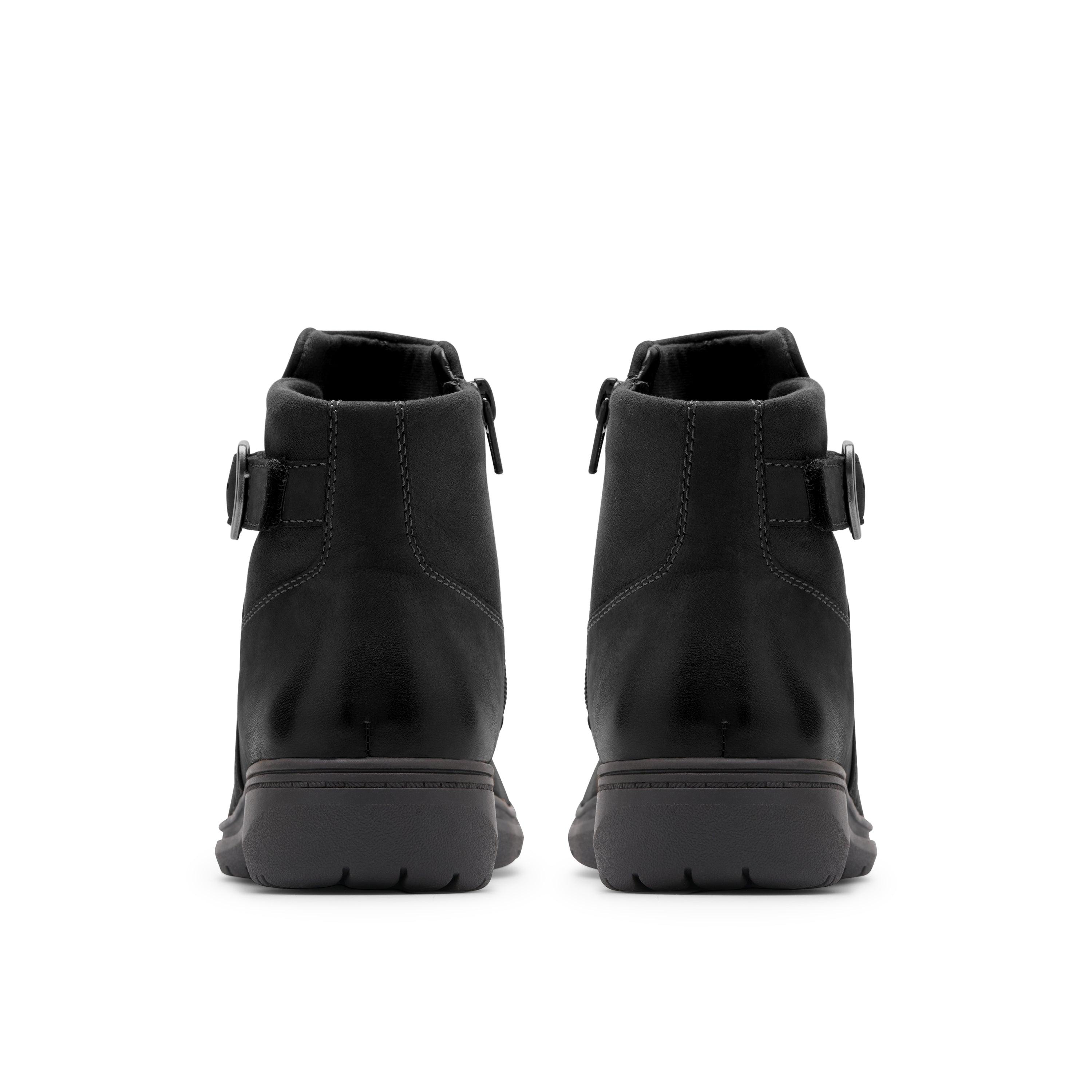A pair of black ankle boots shown from the back, featuring side buckle straps and thick black soles, set against a plain white background.