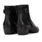 A pair of black leather ankle boots with side buckle straps and low block heels, shown from a rear three-quarter angle on a white background.