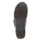 The outsole of a dark brown leather shoe, showing a textured tread pattern and the embossed brand name 'dansko' in the center, isolated on a white background.