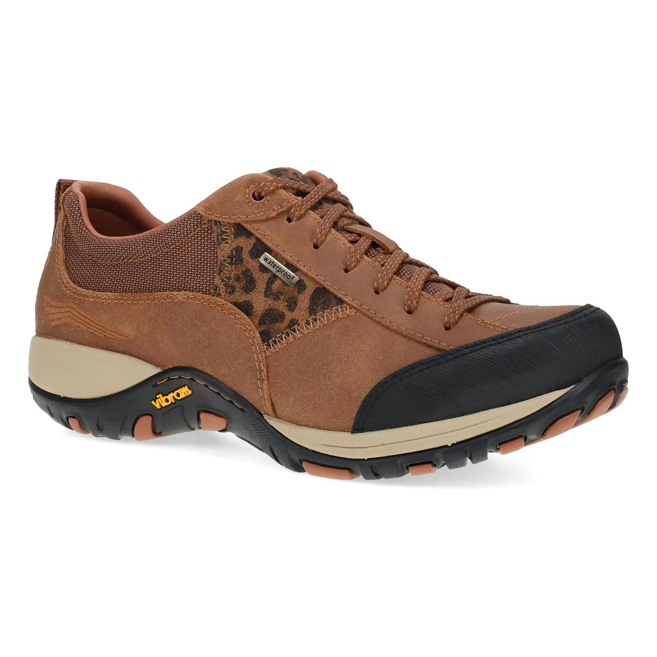 A brown low-top hiking shoe with a leopard-print pattern panel, black toe cap, beige midsole, and Vibram branding on the side, shown against a plain white background.