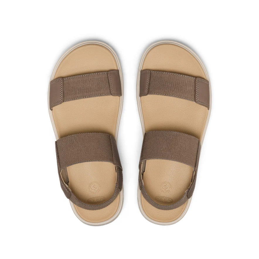 Pair of tan sandals with brown straps on a white background