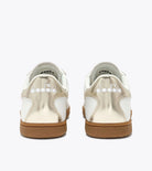 Pair of white sneakers with brown soles on a white background