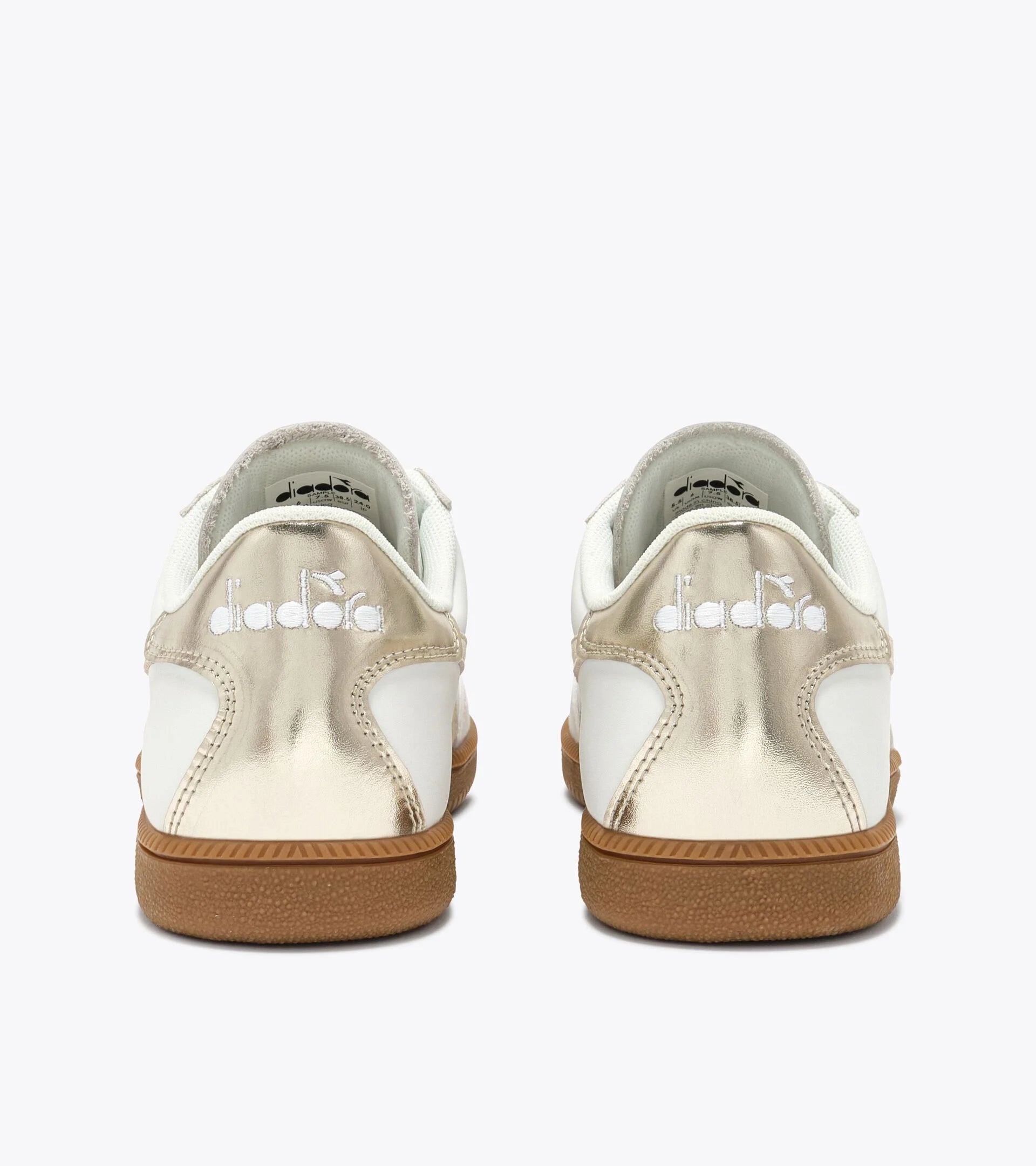 Pair of white sneakers with brown soles on a white background