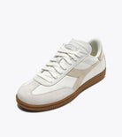 White sneaker with brown sole on a white background