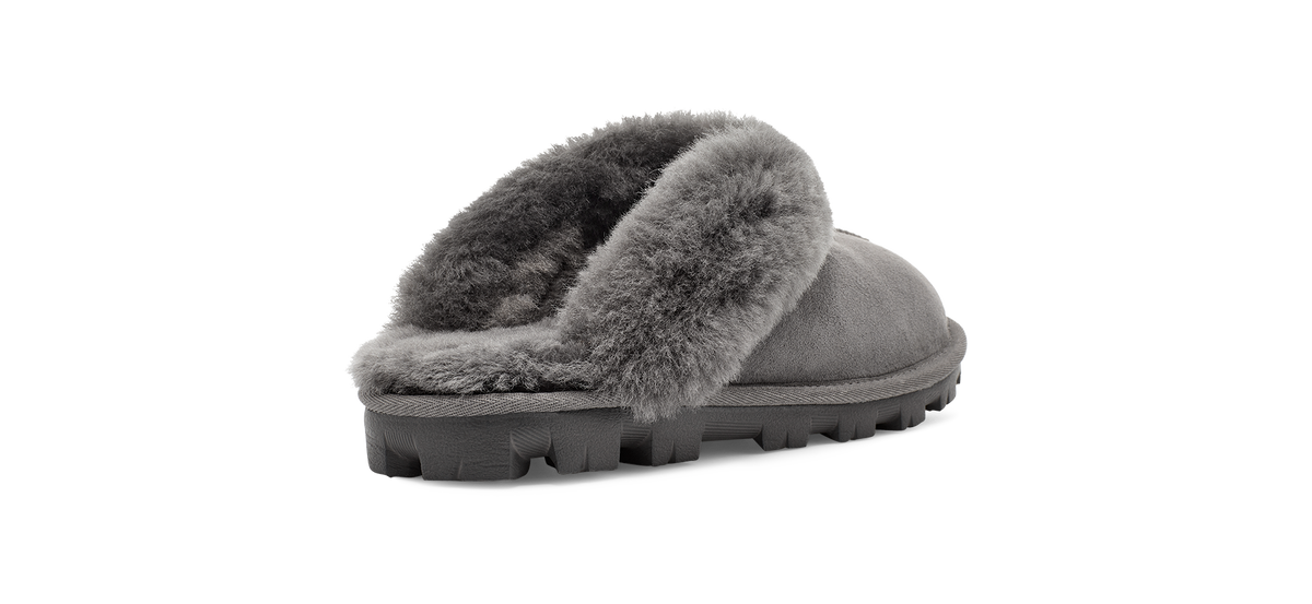 A single gray slip-on slipper with a soft faux-fur trim and a chunky lug sole, shown from a side profile on a white background.