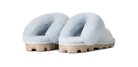A pair of fluffy open-toe slippers with pale blue faux-fur uppers and chunky beige lug soles, shown from the back on a white background.