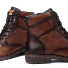 Pair of brown leather boots with visible brand logo on a white background