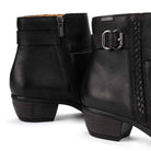 Black leather ankle boots with side zippers, decorative straps, and block heels, shown on a clean white background.