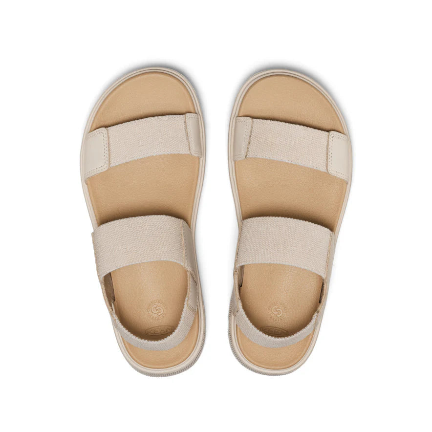Pair of beige sandals with strap details on a white background
