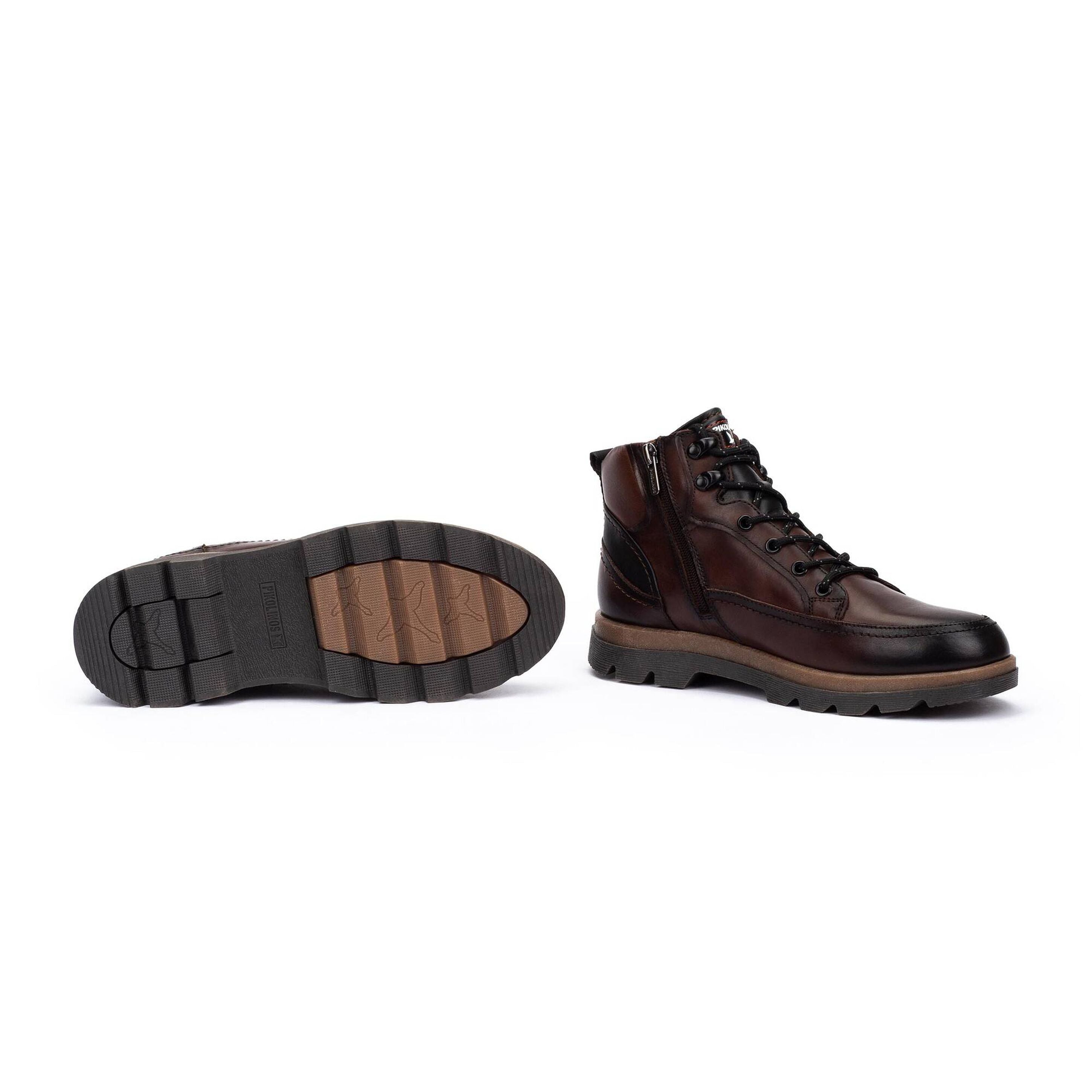 A pair of men's lace-up ankle boots in dark brown leather, shown from the side and sole on a clean white background.