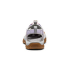 Back view of a sandal with brown sole and white upper on a white background