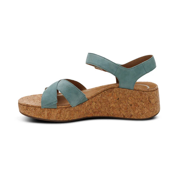 Wedge sandal with cork sole and teal straps on a white background