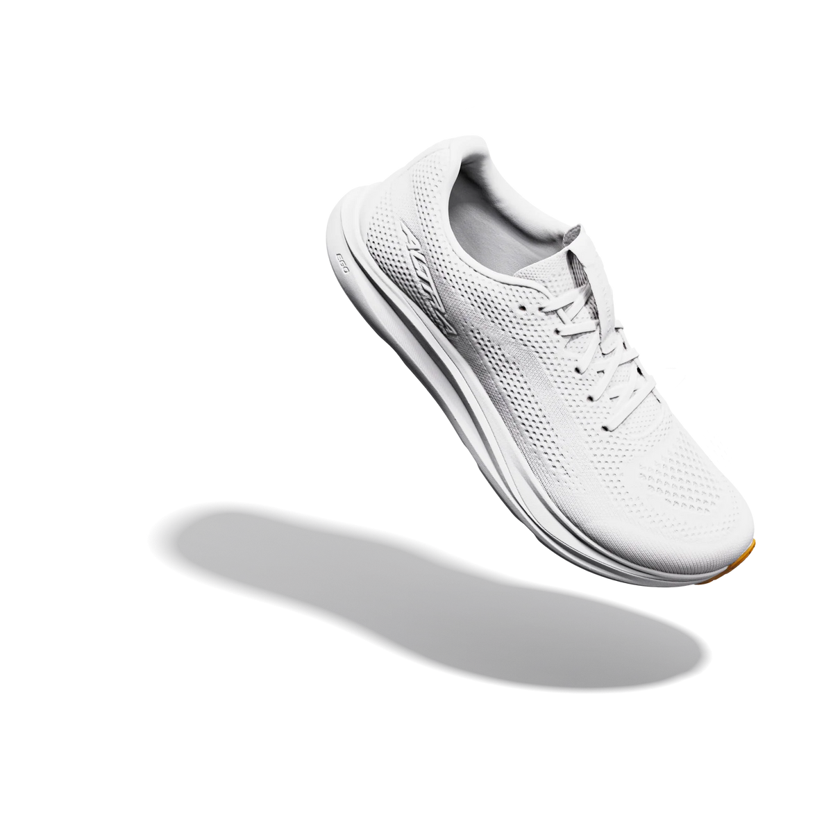 A white athletic sneaker with a breathable mesh upper and thick cushioned sole, shown floating at an angle against a solid white background with a soft shadow underneath.