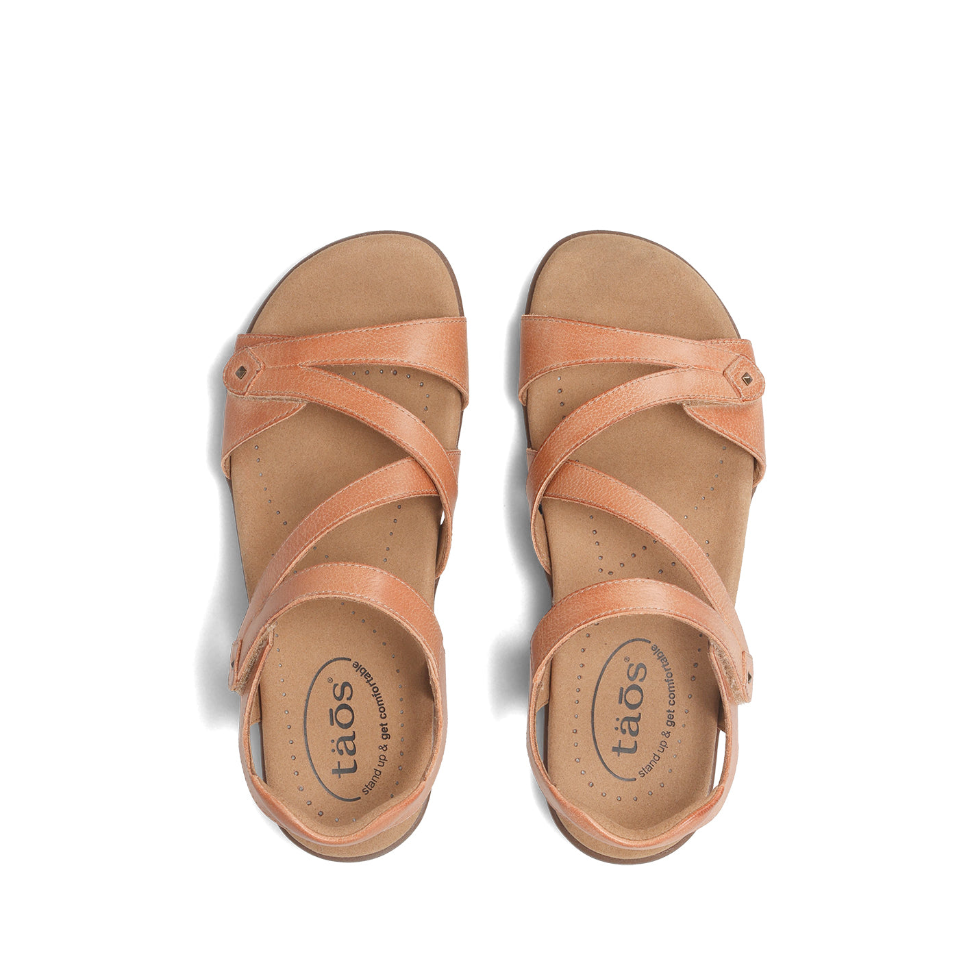 Pair of tan sandals with 'taos' branding on a white background