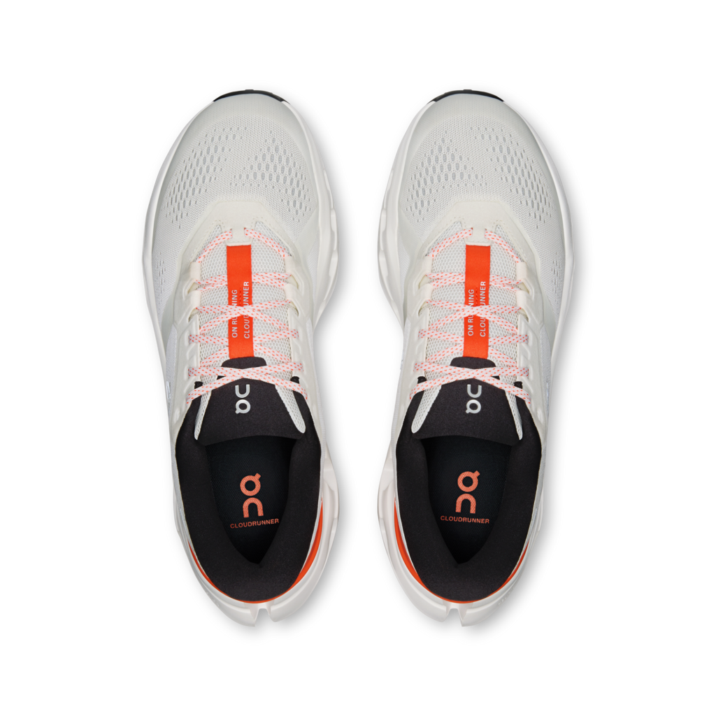 White running shoes with orange accents on a white background