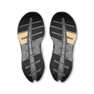 A pair of athletic shoe soles shown from above on a plain white background. The soles are primarily black and dark gray with textured tread patterns and two small tan accents near the heel area.