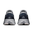 A pair of On running shoes shown from the rear, featuring a navy blue and white design with the brand's logo on the heel counters and a chunky white sole.