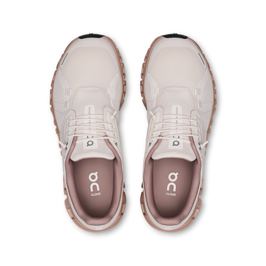 Pair of beige running shoes with a visible brand logo on a white background