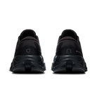 A pair of black athletic sneakers shown from the rear, featuring chunky sculpted soles and textured mesh uppers, set against a plain white background.