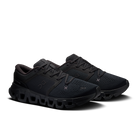 A pair of black On running shoes with textured mesh uppers, matching black laces, and a chunky black sole, displayed on a clean white background.