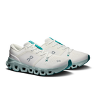 A pair of On Cloudrunning shoes in white with teal accents, featuring the On logo on the side and a distinctive cloud-like sole, set against a plain white background.