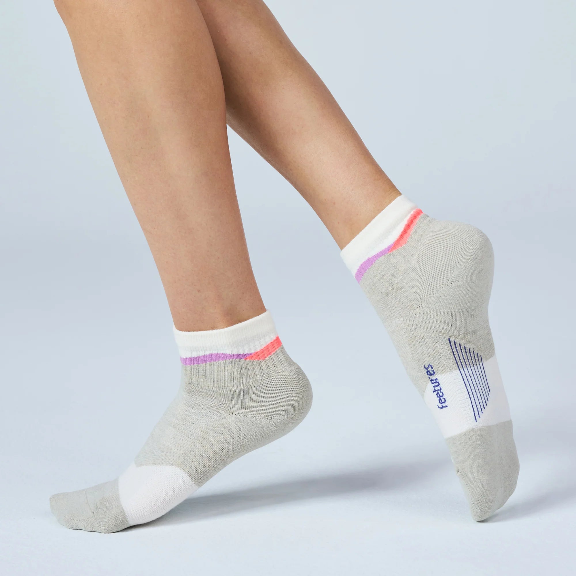 Gray ankle socks with colorful accents worn by a person on a light gray background