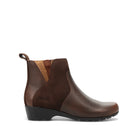 A dark brown leather ankle boot with a black wedge sole, shown in a side profile on a white background. The boot features contrast stitching, elastic side panels, and a pull tab at the heel.
