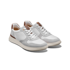 Pair of white sneakers with brown accents on a white background