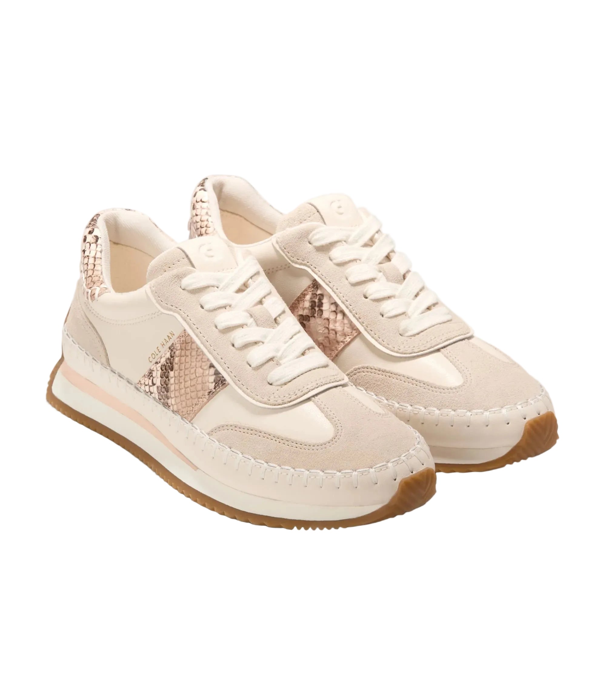 Pair of cream sneakers with brown soles on a white background