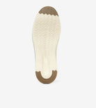 The outsole of a shoe shown from the bottom, featuring a cream-colored center with a wavy tread pattern and brown protective rubber caps at the toe and heel, on a light gray background.