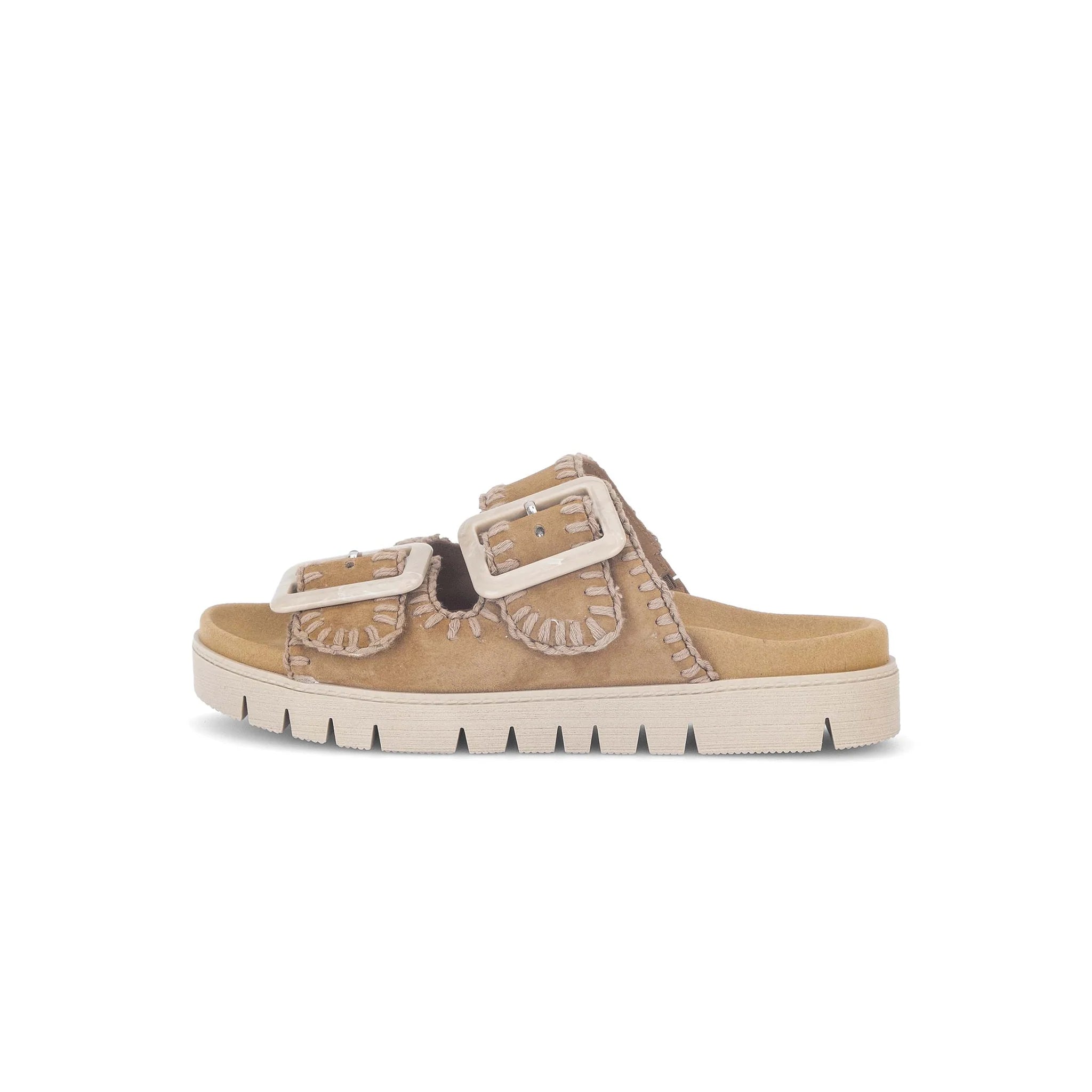 Beige sandal with a buckle on a white background